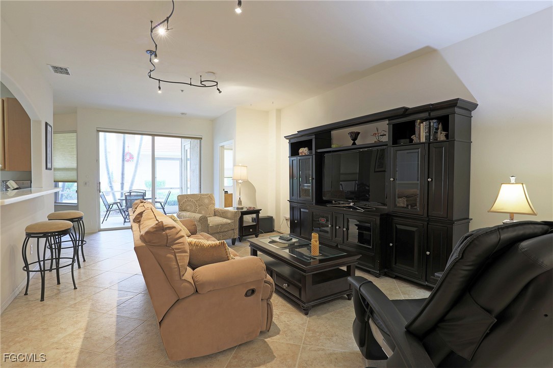 13225 Silver Thorn Loop, Unit 304 North Fort Myers, FL 33903 - Photo 3 of 27 a living room with furniture and a flat screen tv