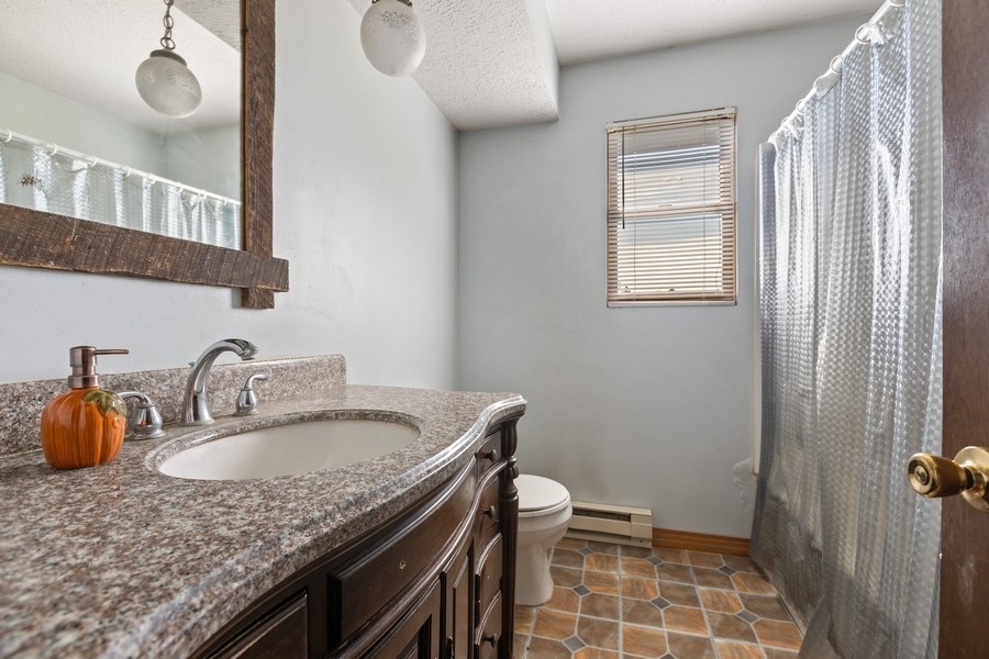 19948 West Mississippi Road Elwood, IL 60421 - Photo 9 of 12 a bathroom with a granite countertop sink a toilet and a mirror