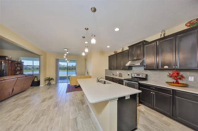 a large white kitchen with lots of counter space a sink and a stove