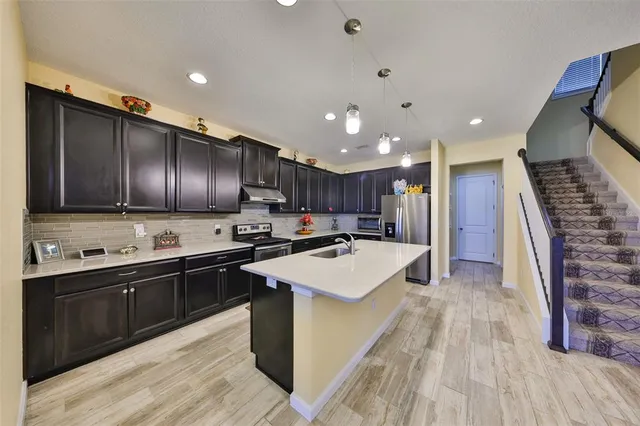 a kitchen with stainless steel appliances a refrigerator and a stove top oven