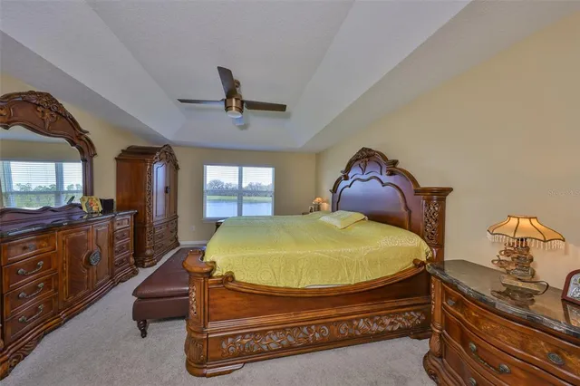 a bed sitting in a room next to a window and a chandelier