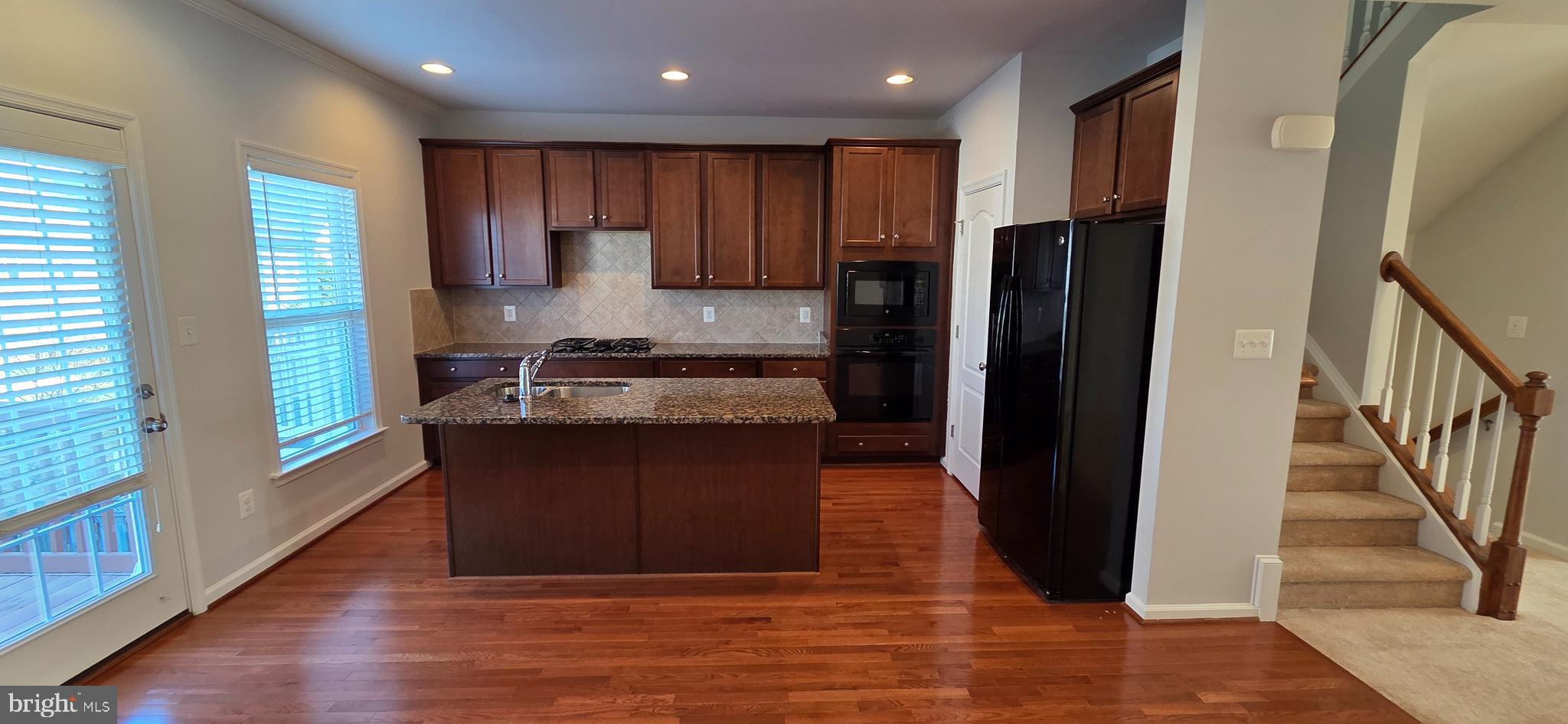 41836 Diabase Square Aldie, VA 20105 - Photo 3 of 29 a kitchen with kitchen island granite countertop a refrigerator and a sink