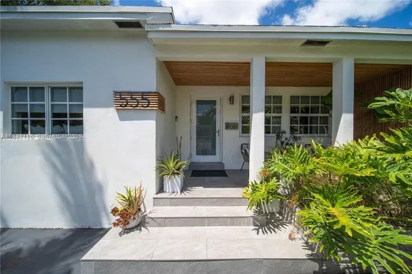 a front view of a house with potted plants