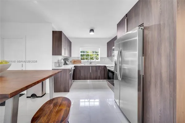 a kitchen with kitchen island a counter top space a sink stainless steel appliances and cabinets