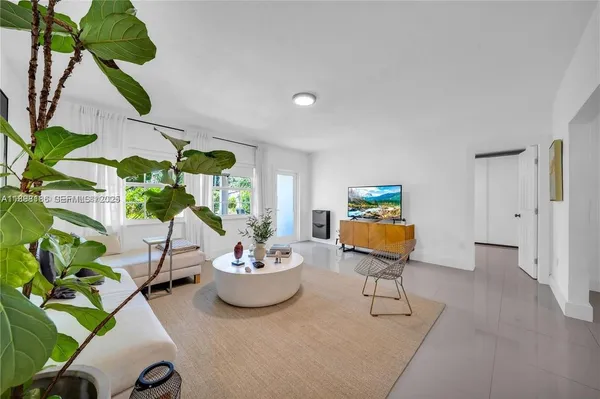 a living room with furniture and a potted plant