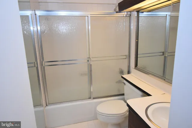 a white toilet sitting next to a shower