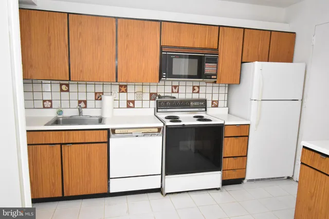 a kitchen with granite countertop white cabinets and white appliances