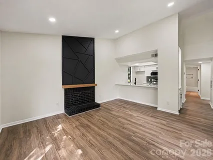 a view of an empty room with wooden floor and closet