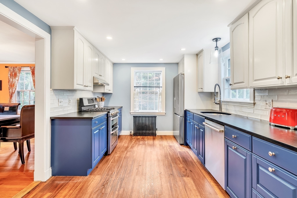 3 White Road Wayland, MA 01778 - Photo 5 of 19 a large kitchen with stainless steel appliances granite countertop a stove a sink dishwasher and a refrigerator with wooden floor
