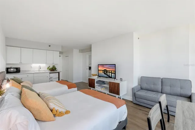 a kitchen with stainless steel appliances white cabinets and wooden floor