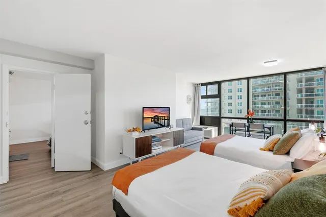 a bedroom with two beds and a large window