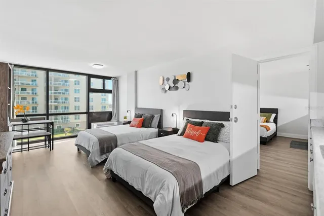 a bedroom with two bed and a dresser in it