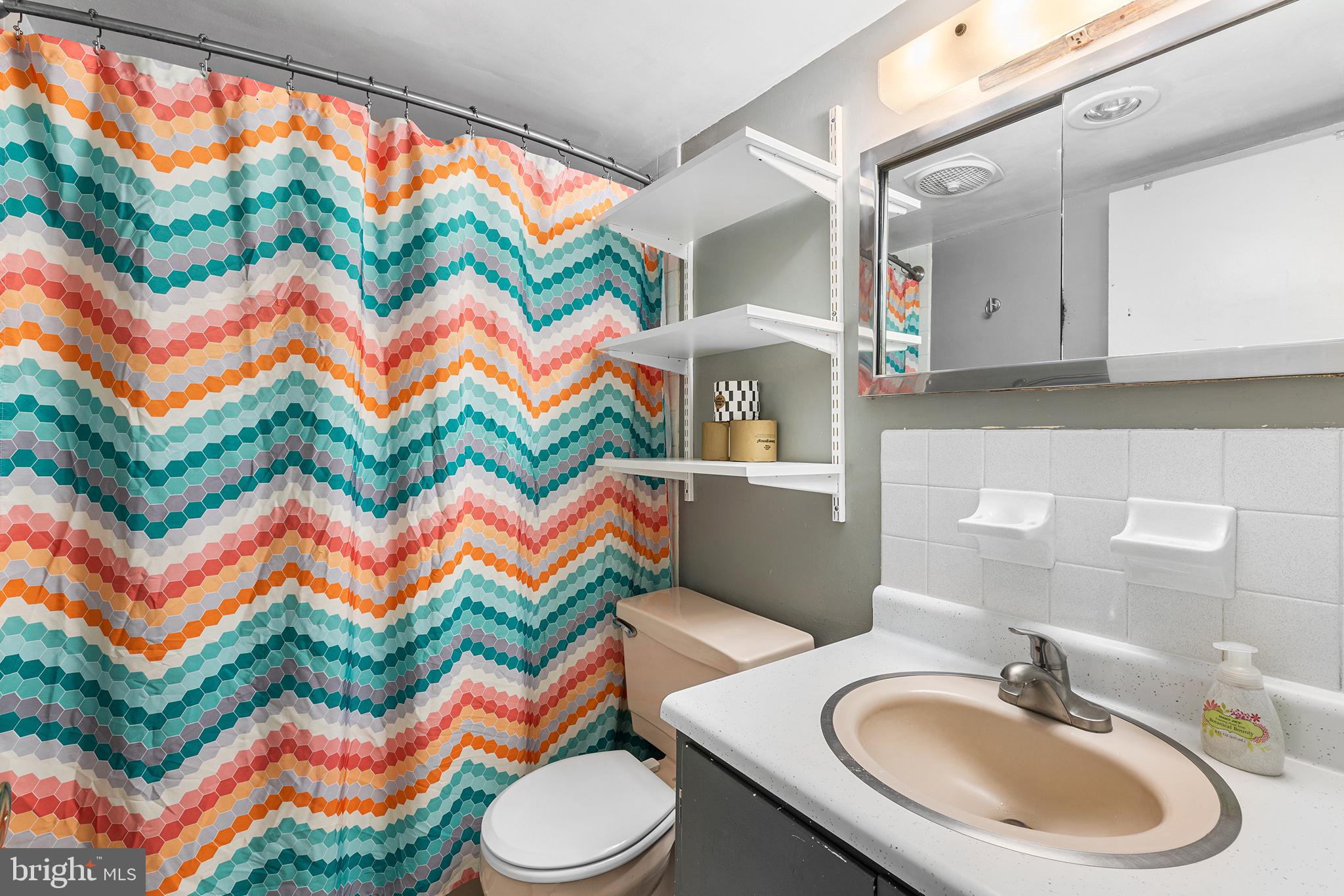 1919 Chestnut Street, Unit 202324 Philadelphia, PA 19103 - Photo 25 of 38 a bathroom with a sink mirror vanity and toilet