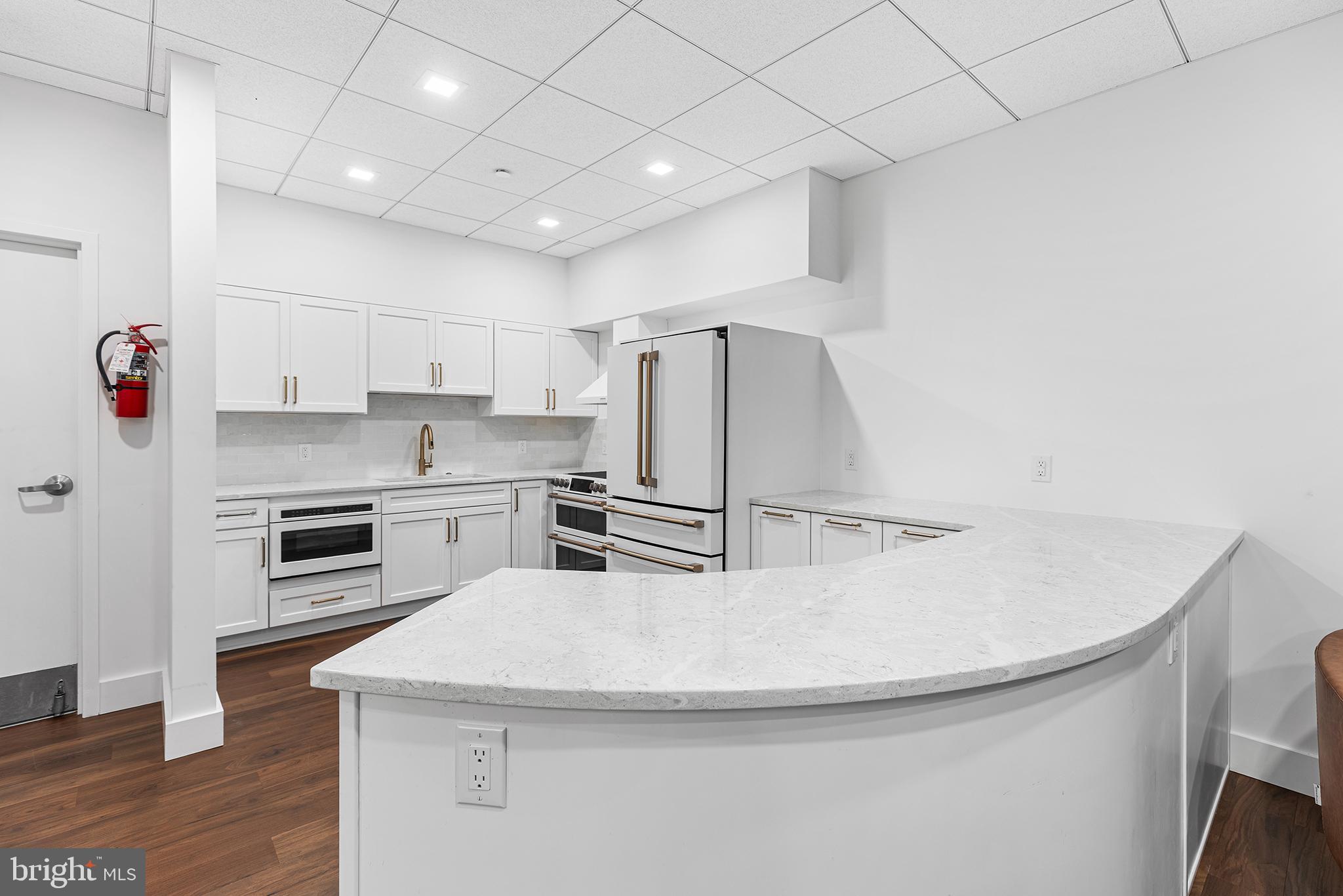 1919 Chestnut Street, Unit 202324 Philadelphia, PA 19103 - Photo 37 of 38 a kitchen with kitchen island a stove a sink and a refrigerator