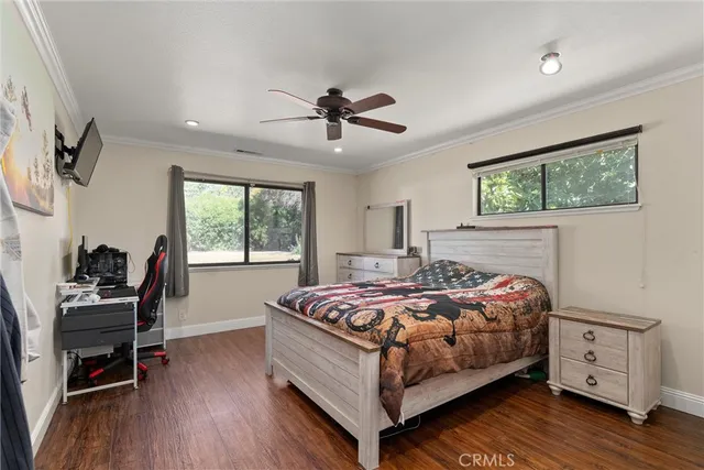 a bedroom with a bed a couch and a flat screen tv