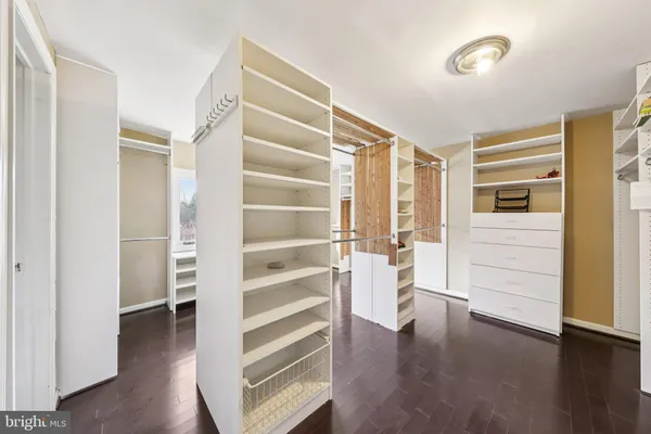 a view of walk in closet with wooden floor and furniture