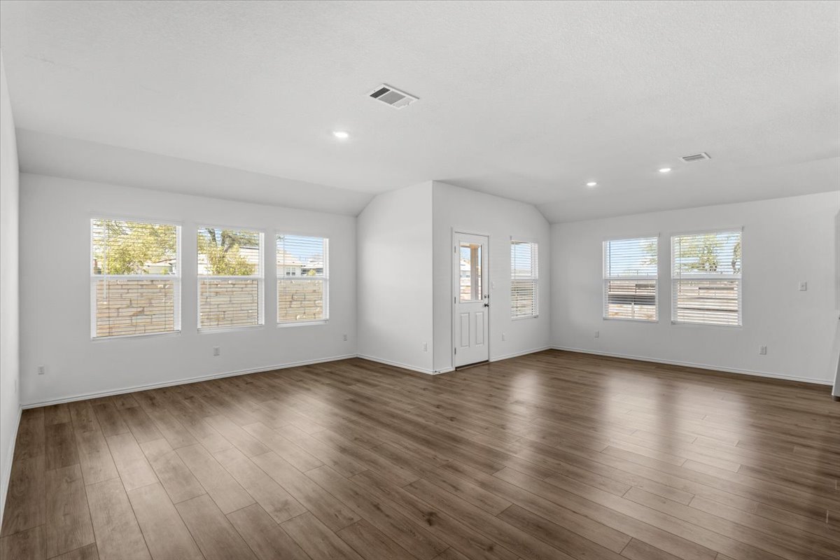 167 Jeffers Kyle, TX 78640 - Photo 7 of 40 Unfurnished living room featuring lofted ceiling, dark wood-type flooring, and recessed lighting