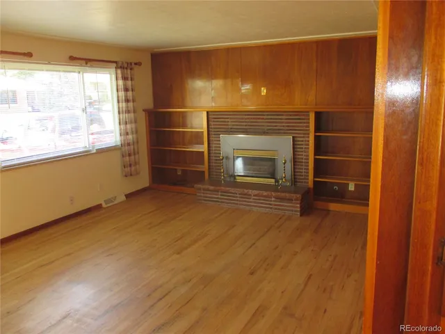 a view of an empty room with a fireplace and a window