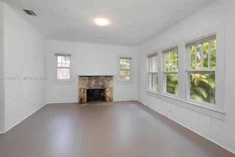 wooden floor fireplace and windows in an empty room