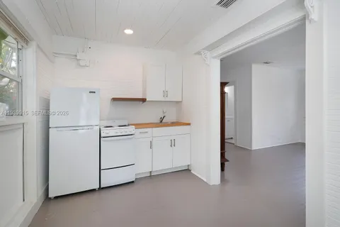 a room with white cabinets and white appliances