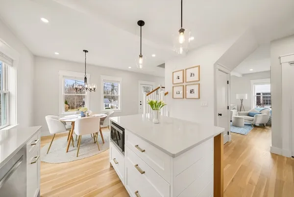 a view of a dining room and livingroom with furniture wooden floor a chandelier