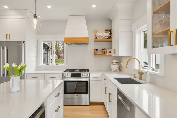 a kitchen with stainless steel appliances granite countertop a sink stove and refrigerator