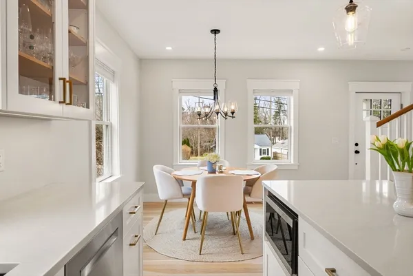 a dining room with furniture a chandelier and wooden floor