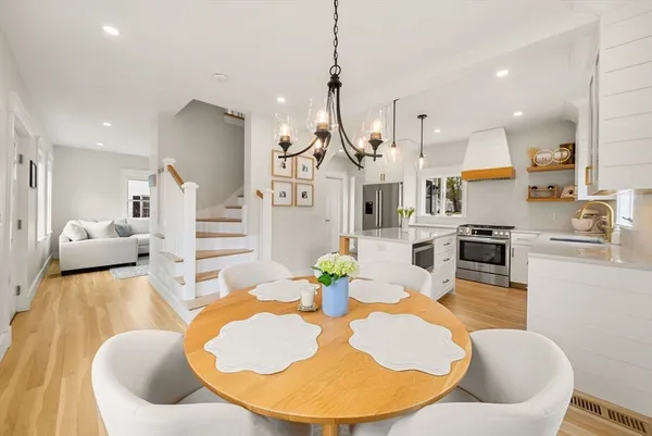 a living room with furniture kitchen view and a wooden floor