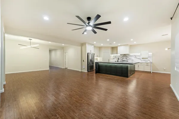 a view of an empty room with a ceiling fan and a window