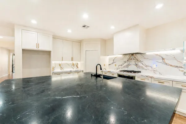 a kitchen with stainless steel appliances granite countertop a stove and a refrigerator