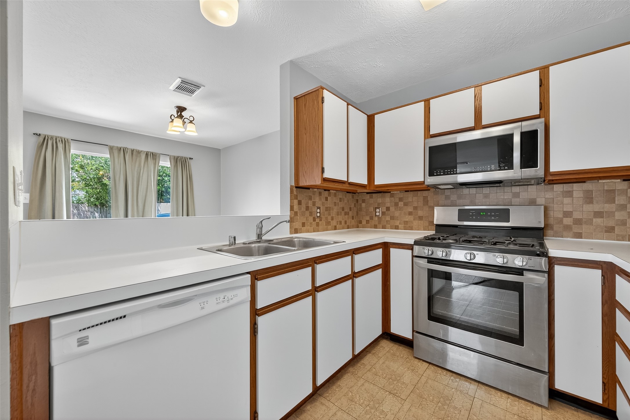 1107 Pennygent Lane Channelview, TX 77530 - Photo 12 of 40 a kitchen with stainless steel appliances granite countertop a stove and a sink