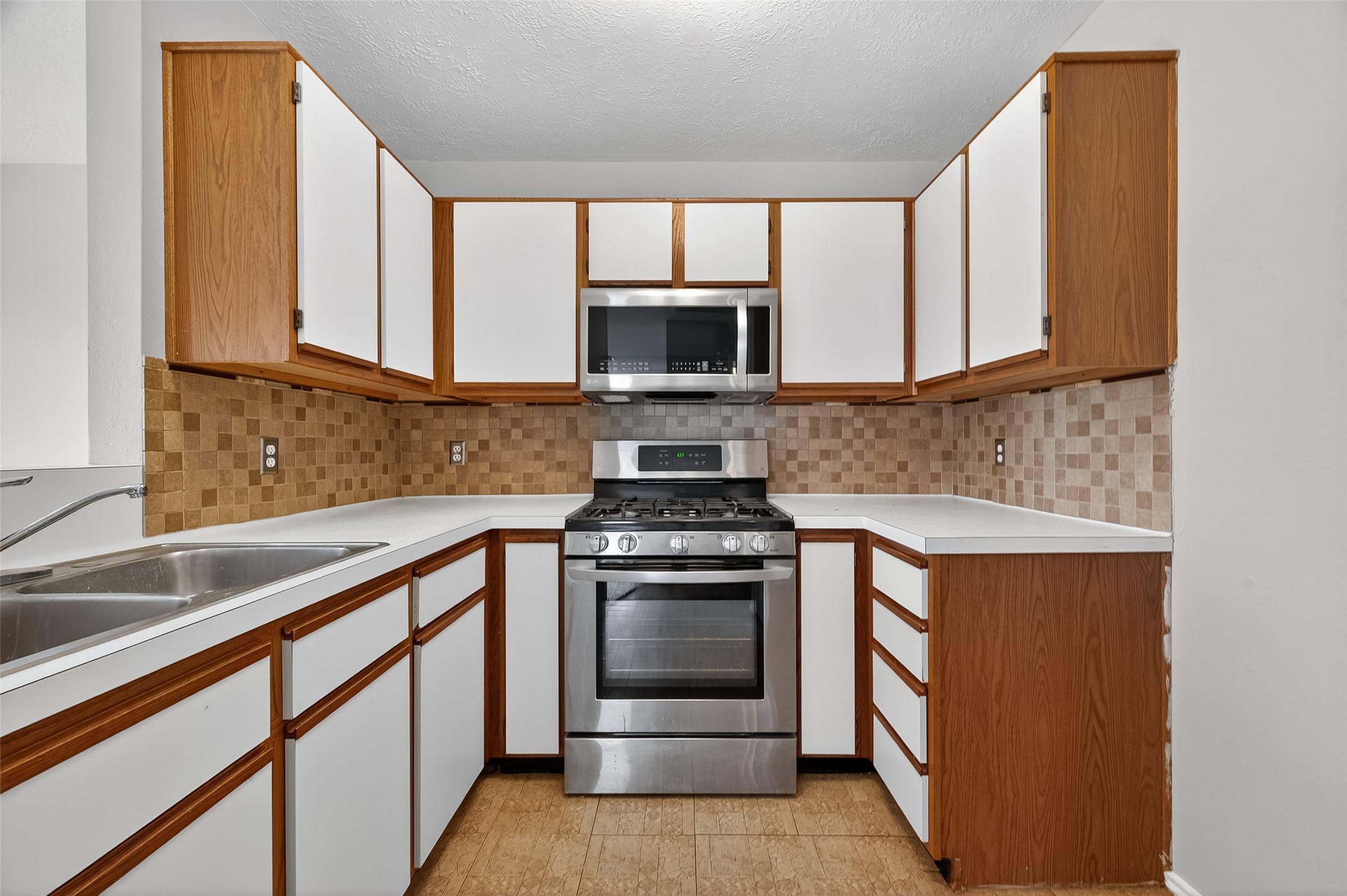 1107 Pennygent Lane Channelview, TX 77530 - Photo 13 of 40 a kitchen with granite countertop a stove and a sink