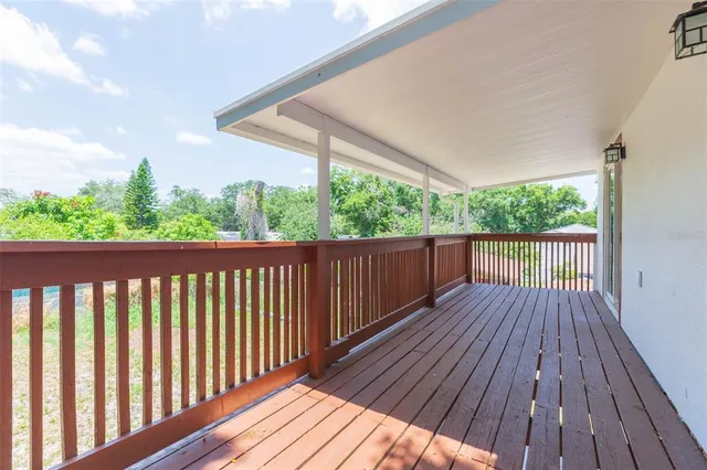 a balcony with wooden floor and outdoor space