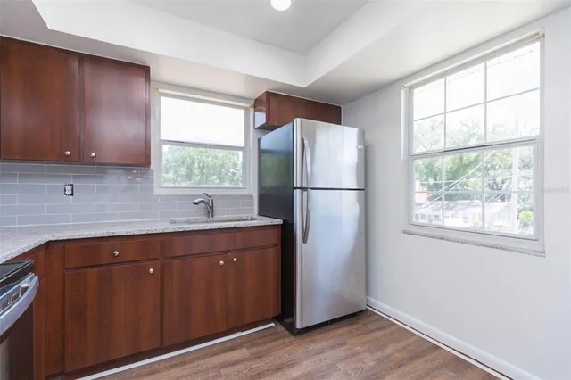 a kitchen with a refrigerator sink and cabinets