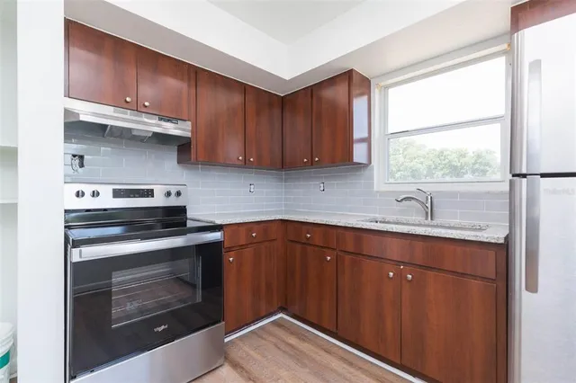 a kitchen with a sink stove and cabinets