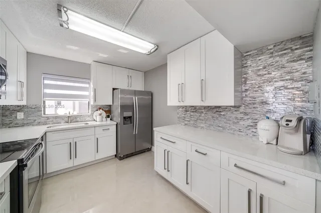 a kitchen with white cabinets and white appliances