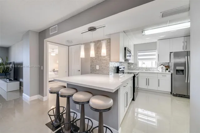 a kitchen with stainless steel appliances granite countertop a stove a sink and a refrigerator