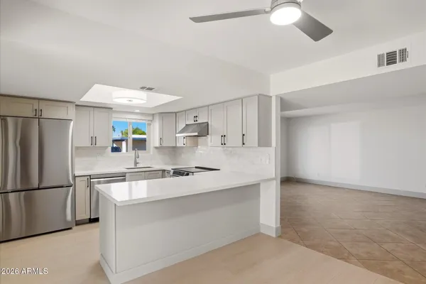 a kitchen with stainless steel appliances white cabinets and a refrigerator