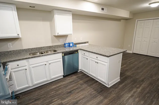 a kitchen with granite countertop white cabinets and white appliances