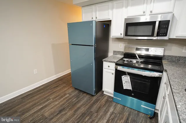 a kitchen with granite countertop wooden cabinets and stainless steel appliances