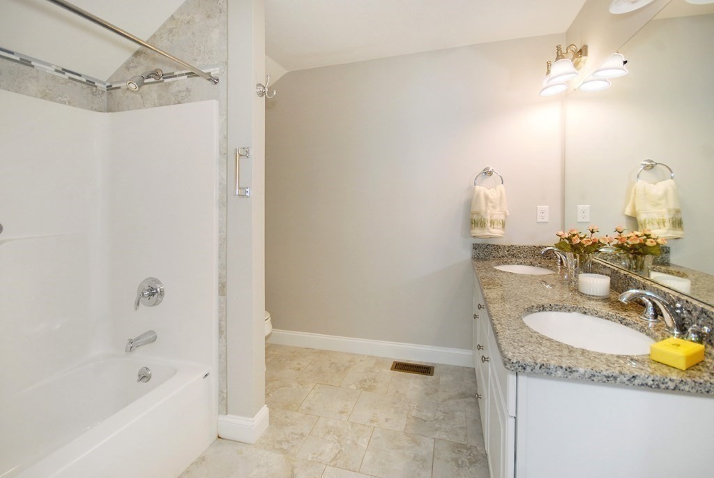 17 Marble Farm Road, Unit 17 Maynard, MA 01754 - Photo 19 of 26 a bathroom with a granite countertop sink a mirror and a bathtub