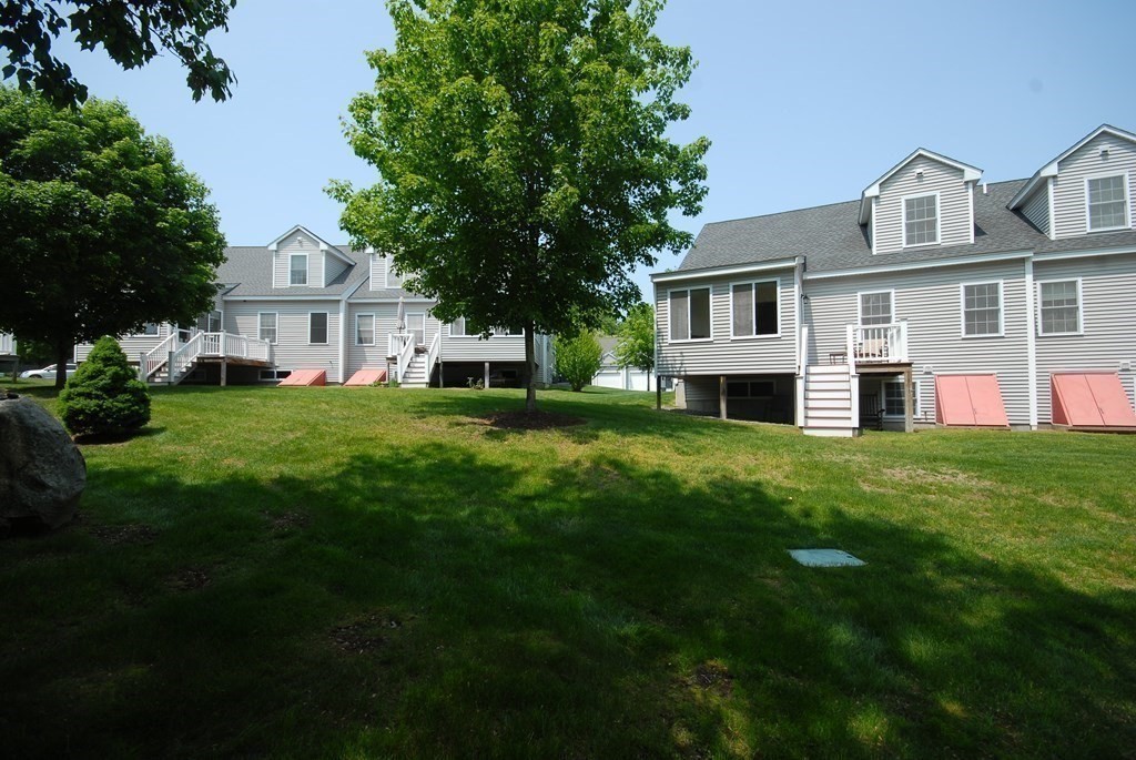 17 Marble Farm Road, Unit 17 Maynard, MA 01754 - Photo 24 of 26 a front view of a house with a garden and trees