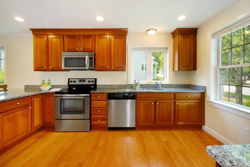 17 Marble Farm Road, Unit 17 Maynard, MA 01754 - Photo 4 of 26 a kitchen with stainless steel appliances granite countertop a stove a sink and a microwave