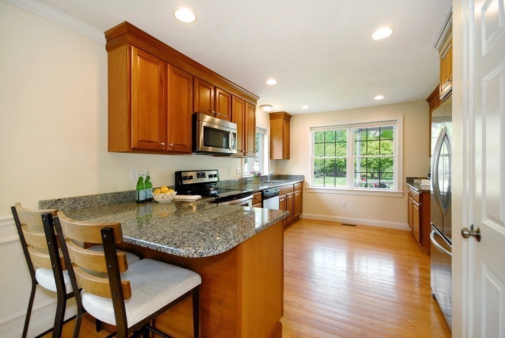 17 Marble Farm Road, Unit 17 Maynard, MA 01754 - Photo 5 of 26 a kitchen with a stove a sink a microwave a dining table and chairs