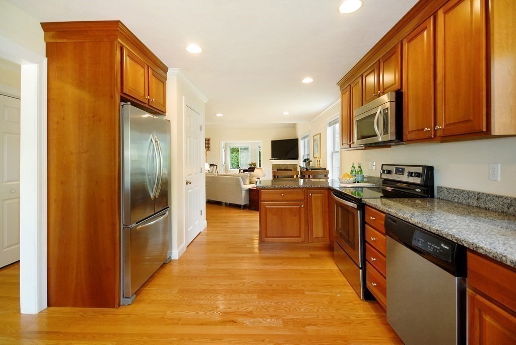 17 Marble Farm Road, Unit 17 Maynard, MA 01754 - Photo 7 of 26 a large kitchen with stainless steel appliances granite countertop a refrigerator a stove top oven and a sink