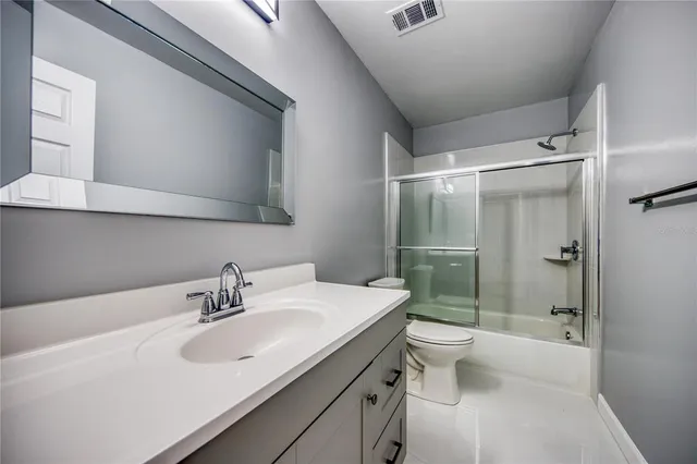 a porch with a table and chairs and potted plants
