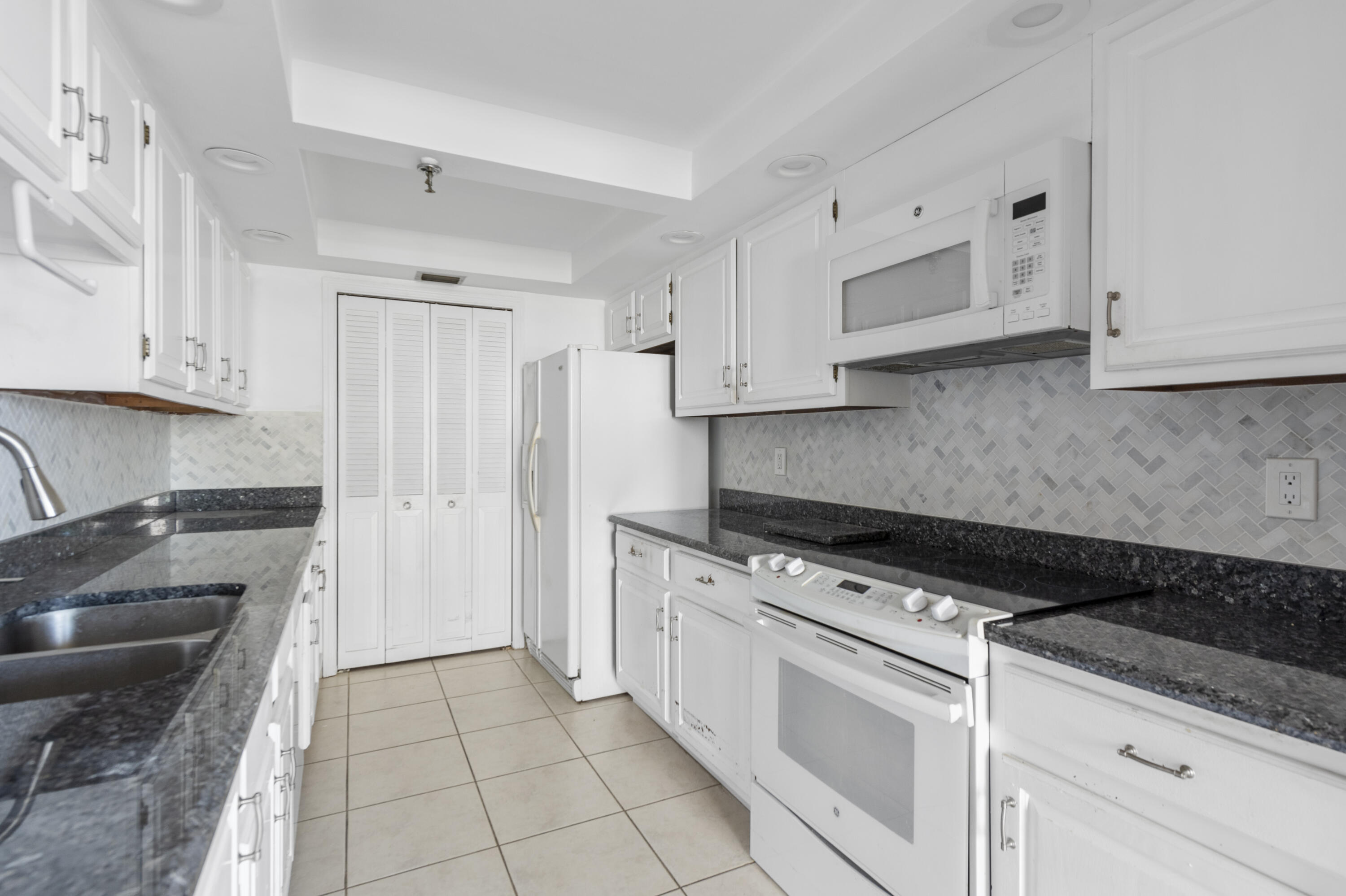 859 Jeffery Street, Unit 312 Boca Raton, FL 33487 - Photo 2 of 53 a kitchen with white cabinets and appliances