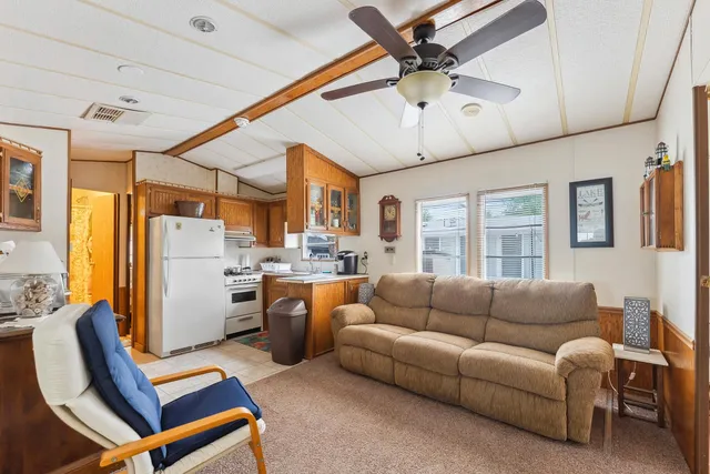 a living room with furniture kitchen view and a window