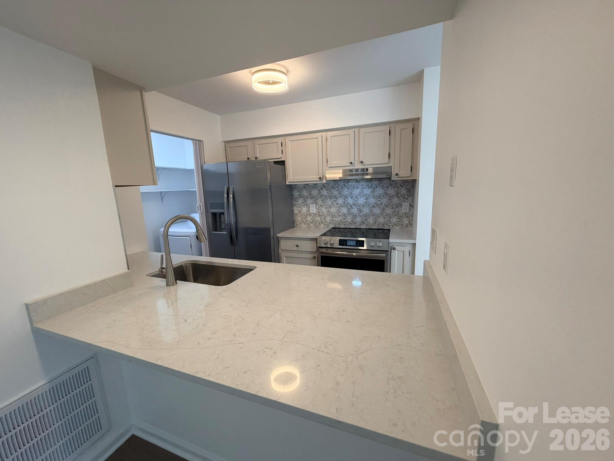 11048 Cedar View Road Charlotte, NC 28226 - Photo 2 of 8 a large white kitchen with a stove a refrigerator a sink a microwave and cabinets