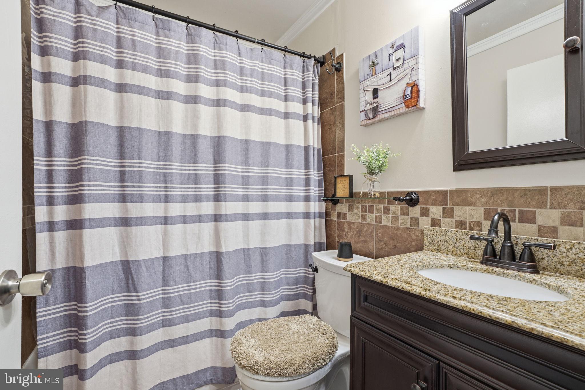 396 Pinewood Drive Levittown, PA 19054 - Photo 21 of 32 a bathroom with a granite countertop bathtub sink vanity mirror and toilet